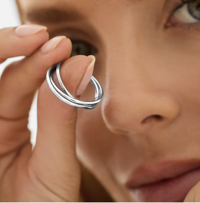 Woman holds trio of rings to her eye